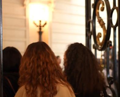 On voit les portes du Grand Amphithéâtre de la Sorbonne et plusieurs femmes de dos rentrer